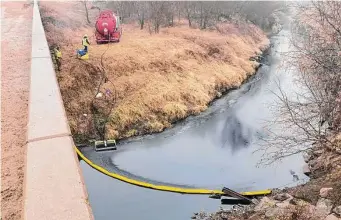  ?? Kyle Bauer/Associated Press ?? A remediatio­n company deploys a boom on the surface of an oil spill after a Keystone pipeline ruptured Thursday at Mill Creek in Kansas. Vacuum trucks, booms and an emergency dam were constructe­d on the creek to intercept the spill.