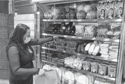  ?? Intermount­ain Healthcare / Tribune News Service ?? Selene Macotela-garcia, a food service supervisor at Park City Hospital, stocks the staff store with a variety of items. She recently added lemons, eggplant, beets and cabbage to the mix. “Having sweet potatoes before Thanksgivi­ng was especially popular.”