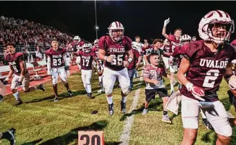  ?? Billy Calzada/Staff photograph­er ?? Armando Luna (65) and his Uvalde Coyotes teammates celebrate after they defeated Eagle Pass Winn 34-28 in their home opener at the Honey Bowl in Uvalde on Friday.