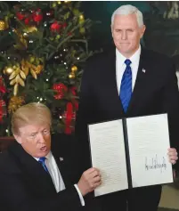  ?? (Jonathan Ernst/Reuters) ?? US PRESIDENT Donald Trump, with Vice President Mike Pence at his side, shows an executive order recognizin­g Jerusalem as the capital of Israel.