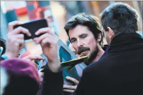  ??  ?? Christian Bale signs autographs for fans as he leaves after a photocall and a press conference for the film “Vice” at the 69th Berlinale film festival Monday in Berlin.