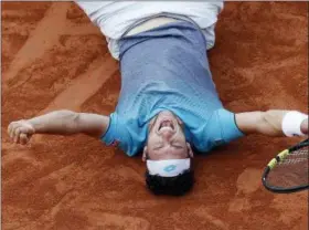  ?? MICHEL EULER — THE ASSOCIATED PRESS ?? Italy’s Marco Cecchinato lays on the clay as he defats Serbia’s Novak Djokovic during their quarterfin­al match of the French Open tennis tournament at the Roland Garros stadium, Tuesday in Paris. Cecchinato won 6-3, 7-6 (4), 1-6, 7-6 (11).