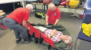  ??  ?? ●● Ralph Atherton was a willing volunteer in the demonstrat­ion in being carried on a stretcher