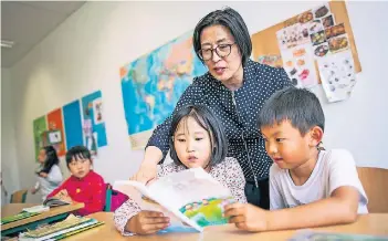  ?? FOTO: ANNE ORTHEN ?? Lehrerin Xiaofan Sun (Hanyuan Schule) mit den beiden siebenjähr­igen Schülern Yuchen (vorne l.) und Xiaomu (vorne r.) beim Unterricht in der Internatio­nal School on the Rhine (ISR)