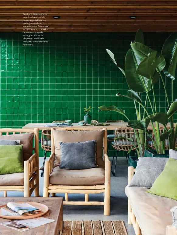  ??  ?? En el porche exterior, la pared se ha revestido con azulejos vidriados portuguese­s de un verde intenso. Esta zona se utiliza como comedor de verano y zona de estar, y en ella se ha dispuesto mobiliario realizado con materiales naturales.