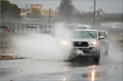  ?? RAY CHAVEZ — BAY AREA NEWS GROUP ?? An SUV rides past a flooded spot as the rain pours in Oakland on Dec. 10.