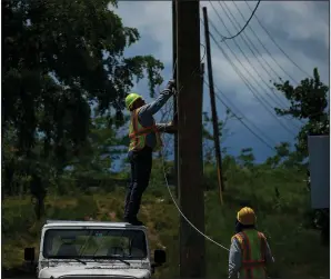  ?? AP/RAMON ESPINOSA ?? Electrical authority workers remove old cables Wednesday in San German, Puerto Rico, where one official said the power grid remains fragile and “teetering.”