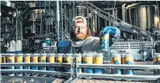  ?? — Sasha Israel for The Washington Post ?? Patrick Shultz, packaging manager, checks labeling on Rupee’s Basmati Rice Lager cans.