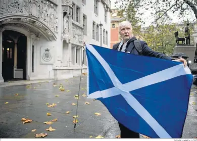  ?? TOLGA AKMEN / EFE ?? Un activista sostiene ayer una bandera escocesa frente al Tribunal Supremo del Reino Unido en Londres.
