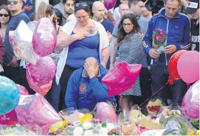  ?? AP ?? Parents Charlotte Campbell and Paul Hodgson, centre, whose daughter Olivia lost her life this week, mourn outside Manchester Arena.