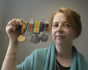  ?? BERNARD WEIL/TORONTO STAR ?? Sue Motahedin holds some of the medals found in a vault at the TTC office. Some date back to the First World War.