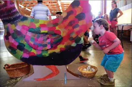  ?? TANIA BARRICKLO - DAILY FREEMAN ?? Two-year-old Ronan Lavery, son of Ross and Breanne of Red Hook, tries to put an “egg” back into a wooden chicken that lays ping pong balls in the poultry barn at the 174th Annual Dutchess County Fair on Tuesday.