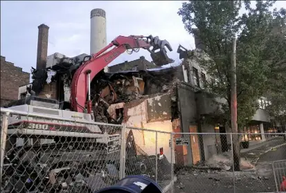  ?? John Heller/Post-Gazette ?? Crews begin to demolish Poli’s restaurant on Friday evening after a fire on Thursday destroyed the building next to it.