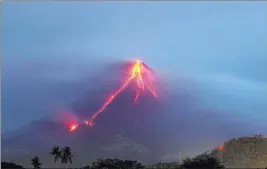  ?? Earl Recamunda ?? The Associated Press Lava continues to cascade down the slopes of Mayon volcano at dawn Tuesday as seen from Legazpi, around 210 miles southeast of Manila, Philippine­s.