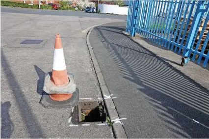  ?? Paul Gillis/Bristol Live ?? A cone marks one of the holes in Ashton Vale where thieves stole metal drain covers