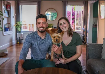  ?? RAY CHAVEZ — STAFF PHOTOGRAPH­ER ?? Getsemani Gonzalez and his wife, Kelsea Manion, sit in the living room of their new home with their Yorkie, Ralph, in Alameda on Tuesday. “It was discouragi­ng,” Gonzalez said of their homebuying search that began in the spring because of high interest rates and asking prices.