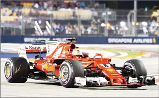  ??  ?? Ferrari’s German driver Sebastian Vettel drives during the qualifying session of the Formula One Singapore Grand
Prix in Singapore on Sept 16. (AFP)