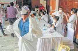  ?? PTI ?? A health worker wearing PPE kit reacts as he opens the suit during a testing camp at a containmen­t zone in Gurugram on Saturday.