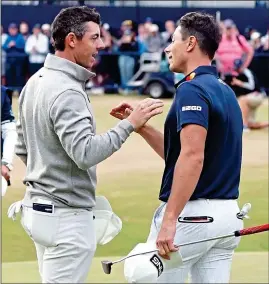  ?? ?? SHAKE ON IT: Joint leaders McIlroy (left) and Hovland congratula­te one another after a thrilling day’s golf on the Old Course yesterday