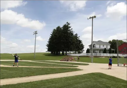  ?? CHARLIE NEIBERGALL ?? Visitors play on the field at the Field of Dreams movie site, Friday, June 5, 2020, in Dyersville, Iowa. Major League Baseball is building another field a few hundred yards down a corn-lined path from the famous movie site in eastern Iowa but unlike the original, it’s unclear whether teams will show up for a game this time as the league and its players struggle to agree on plans for a coronaviru­s-shortened season.