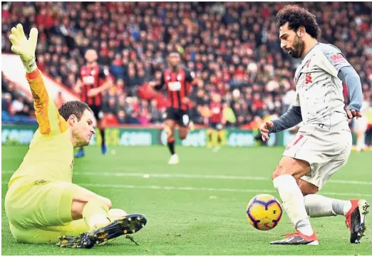  ?? — AFP ?? Liverpool’s Mohamed Salah rounding Bournemout­h goalkeeper Asmir Begovic before completing his hattrick in the English Premier League match at the Vitality Stadium yesterday. Liverpool won 4- 0.