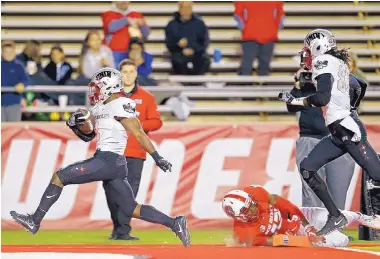  ?? ANDRES LEIGHTON/ASSOCIATED PRESS ?? UNLV running back Lexington Thomas, left, scores a first-half touchdown, getting past UNM’s Jalin Burrell (13).