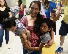  ?? — AP ?? Together again: Godinez with her children at Miami Internatio­nal Airport.