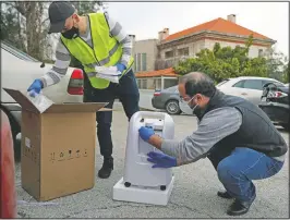  ??  ?? Firas Minnawi (right) and Mario Suleiman unpack an oxygen machine to be donated to an elderly covid-19 patient in Beit Shebab, a mountain village 15 miles north of Beirut.