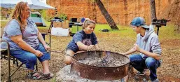  ??  ?? Michelle and Selena Smith and Mason Ellis, of Oklahoma City, get their campfire started Nov. 2 at Red Rock Canyon Adventure Park.