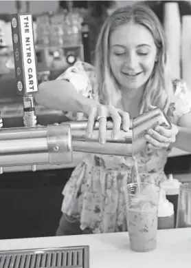  ?? ALEX COTTON/ NEWPORT DAILY NEWS, FILE ?? Audrey Finocchari­o, co-owner of the Nitro Bar in Newport, mixes up a craft coffee drink in 2019.