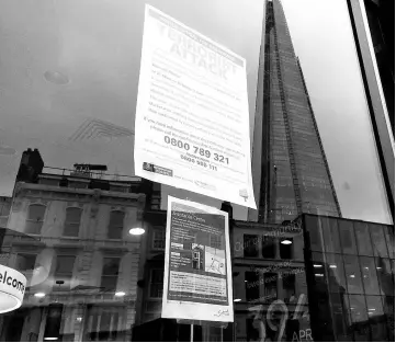  ??  ?? A sign posted in a storefront at Borough Market calls for informatio­n about the June attack. A reflection of the Shard, the tallest building in Western Europe, appears in the glass.