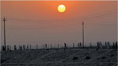  ??  ?? People jog as the sun rises over the Ganges river in Allahabad, on Sunday. Heat wave conditions prevailed across north India on Sunday with the mercury hovering above 40 degrees Celsius mark in many areas. It was a hot Sunday for Delhiites, with the...
