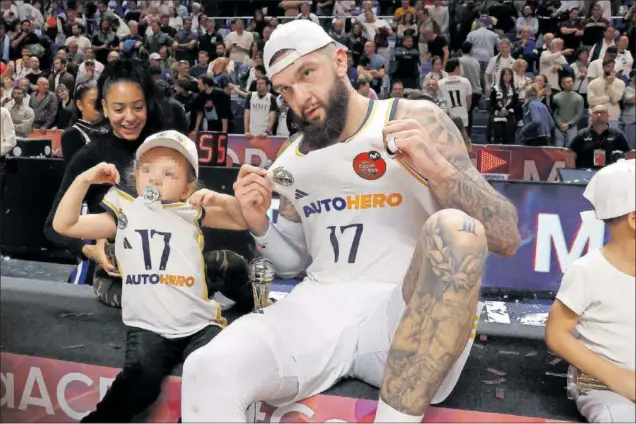  ?? ?? Vincent Poirier celebra en el Carpena con su hija, que imita su gesto para la foto, y su mujer su sexto título con el Real Madrid, su primera Copa.