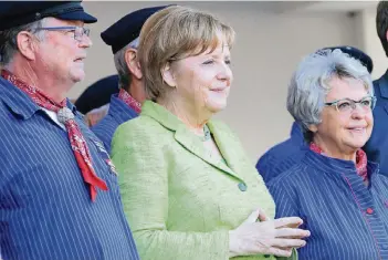  ?? FOTO: IMAGO ?? Angela Merkel singt im Konzertgar­ten West der Stadt Kühlungsbo­rn mit einem Shanty-Chor.