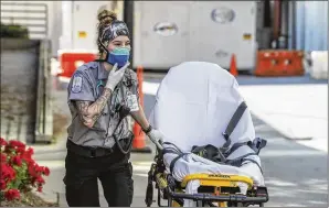  ??  ?? Grady Advanced EMT Emma Hovis, on the front line of the COVID-19 epidemic, prepares for another patient call on Monday. Healthcare executives and state officials must find more doctors and nurses to staff overflow hospitals, medics to transport patients and backfill for healthcare workers who become infected.