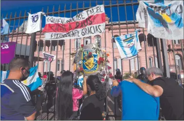  ??  ?? Mourning… Fans mourn as the funeral cortege of Argentinia­n late football legend Diego Armando Maradona leaves the Casa Rosada government house to the cemetery, in Buenos Aires on Thursday.