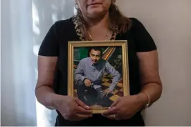  ??  ?? Rosa, an immigrant from El Salvador, holds a photograph of her son José, 27, who is currently stuck in Juarez, Mexico, on 25 July. Photograph: Jason Andrew/The Guardian