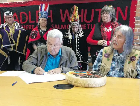  ?? GORDON HOEKSTRA/VANCOUVER SUN ?? George George Sr., whose Nadleh Whut’en hereditary leadership name is Yutunayeh, signs a water policy declaratio­n that covers the traditiona­l territory of his First Nation and that of the Stellat’en. Nadleh Whut’en chief Martin Louie looks on.