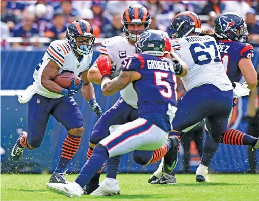  ?? QUINN HARRIS/GETTY IMAGES ?? Running back Khalil Herbert finds the opening the Bears’ line created for him, leading to a huge first down against the Texans.