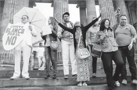  ?? Mario Tama Getty Images ?? SUPPORTERS of Colombia’s peace agreement with FARC rebels gather next to a lone demonstrat­or, far left, calling for a “no” vote on the accord. It has already been signed, but the political fallout from a popular rejection of the deal probably would...