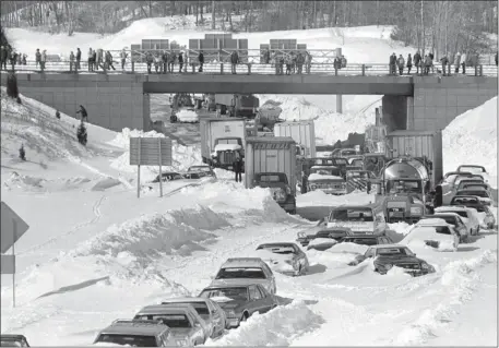  ?? AP PHOTO ?? Cars and trucks stranded and abandoned in deep snow along Route 128 in Dedham are seen in this Feb. 9, 1978 photo, as military and civilian plows begin to dig them out during the Blizzard of 1978.