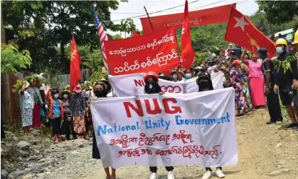  ?? ?? Protesters marching with banners supporting the opposition National Unity Government. Photograph: Kachinwave­s/AFP/Getty Images