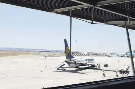  ?? EL PERIÓDICO ?? Un avión de la compañía irlandesa Ryanair, en la pista de estacionam­iento del aeropuerto de Zaragoza, se prepara para recibir a los pasajeros.