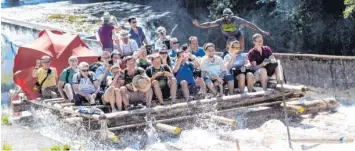  ?? Foto: Sven Hoppe, dpa ?? Rasante Floßfahrt auf der Isar. Die Gäste sind in bester Stimmung. Möglich macht es Jason Charles, stehend rechts vorne auf dem Floß. Er kommt aus der Karibik und ist Bayerns einziger schwarzer Flößer.