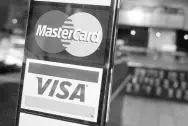  ?? AP ?? This photo shows logos for MasterCard and Visa credit cards at the entrance of a New York coffee shop.