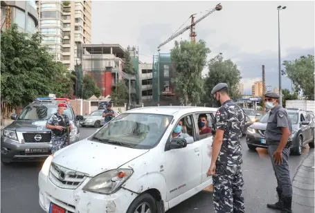  ?? File/AFP ?? Security forces man a checkpoint in Beirut as part of restrictio­ns to combat COVID-19. Lebanon’s total number of cases has exceeded 20,000.