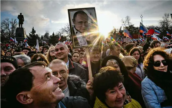  ?? Yuri Kadobnov/AFP ?? Apoiadores do presidente Vladimir Putin celebram o quarto aniversári­o da anexação da Crimeia pela Rússia, em praça de Sebastopol, naquela região