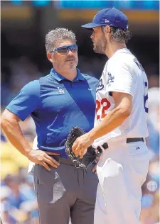  ?? ALEX GALLARDO/ASSOCIATED PRESS ?? Dodgers trainer and native New Mexican Nathan Lucero talks with pitcher Clayton Kershaw during a game earlier this year. Lucero began his pro career with the Houston Astros.