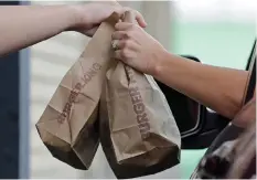  ?? ALAN DIAZ AP ?? A CUSTOMER picks up an order at a Burger King drive-thru in Miami. Burger King is the darling of the GPI board at present. |