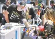  ?? Brian Peterson / Associated Press ?? Vikings tight end Kyle Rudolph hands out ice cream to children waiting in line at the “Change Starts with Me” food and household supply giveaway outside a Cub Foods store in Minneapoli­s on June 5.